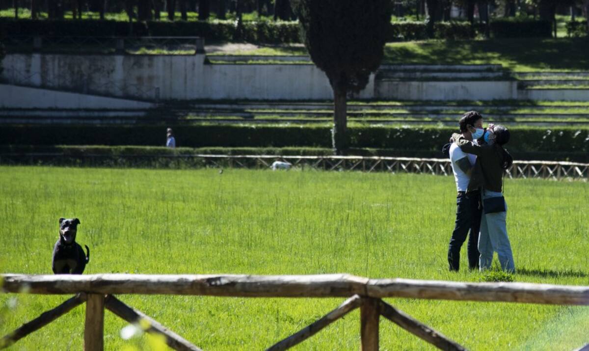 Una pareja se sienta en un banco en el parque de Villa Borghese en Roma el 4 de mayo de 2020, durante el cierre del país destinado a frenar la propagación de la infección por Covid-19.