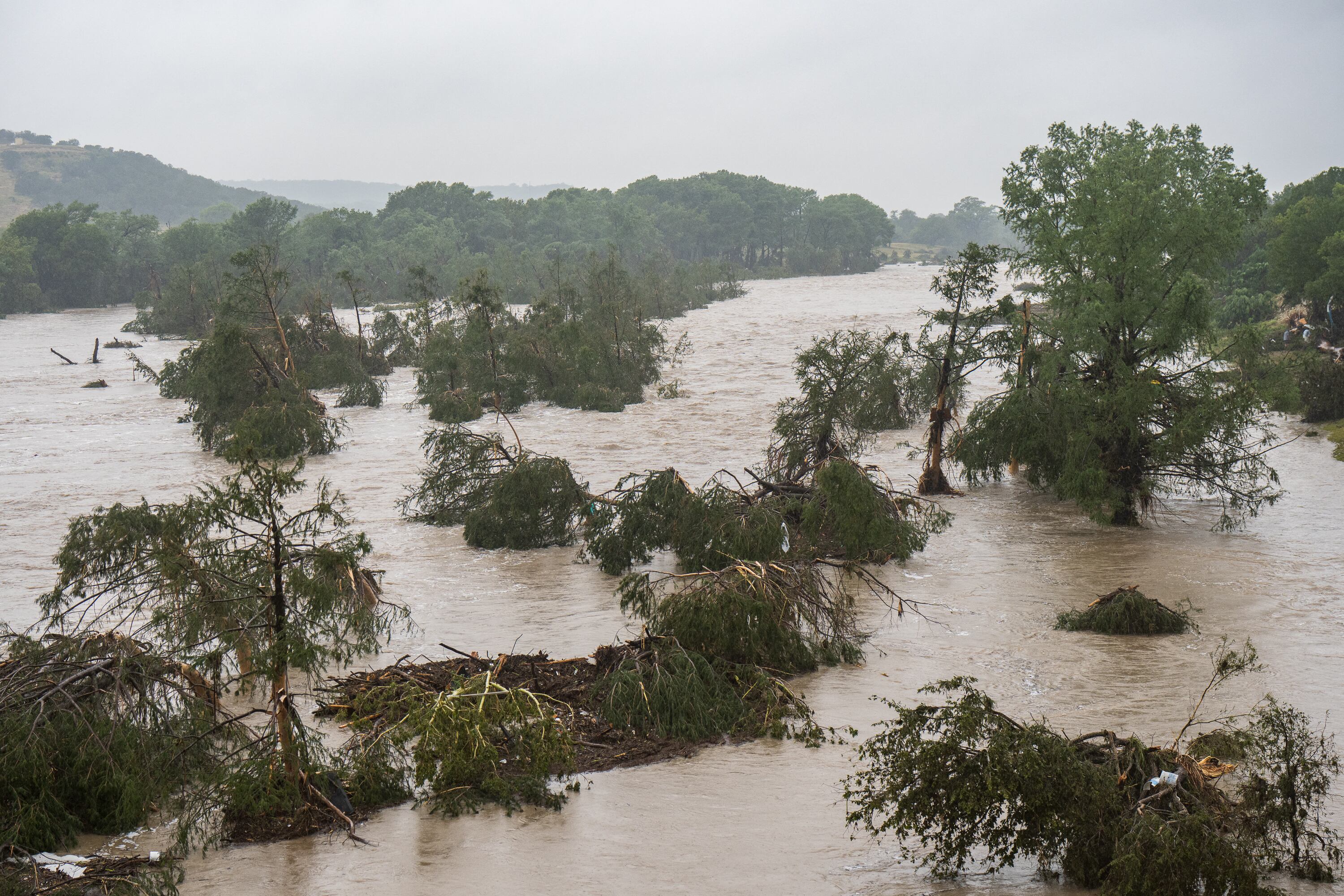 KERRVILLE, TEXAS - JULY 04: Trees emerge from flood waters along the Guadalupe River on July 4, 2025 in Kerrville, Texas. Heavy rainfall caused flooding along the Guadalupe River in central Texas with multiple fatalities reported.   Eric Vryn/Getty Images/AFP (Photo by Eric Vryn / GETTY IMAGES NORTH AMERICA / Getty Images via AFP)