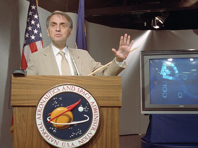 El astrónomo Carl Sagan habla en una conferencia de prensa donde la NASA puso a disposición las últimas fotografías tomadas por la Voyager 1, que muestran el sistema solar visto desde el exterior / Getty Images
