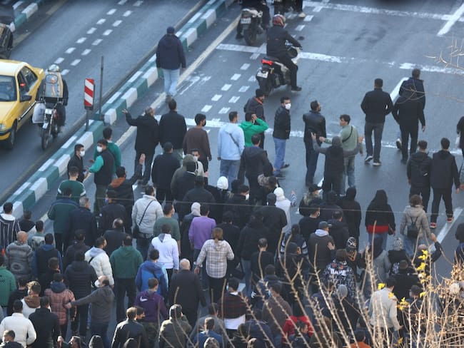 Shopkeepers and traders protest in the street against the economic conditions and Iran's embattled currency in Tehran on December 29, 2025. Some shopkeepers in Tehran closed their stores on December 29 in protest against economic hardships and sharp swings in Iran's embattled currency, Iranian media reported, following similar demonstrations a day earlier. Iran's currency has hit new lows on the unofficial market, with the US dollar trading at around 1.42 million rials on Sunday, compared to 820,000 rials a year ago and the euro nearing 1.7 million rials, according to price monitoring websites. (Photo by HANDOUT / FARS NEWS AGENCY / AFP)