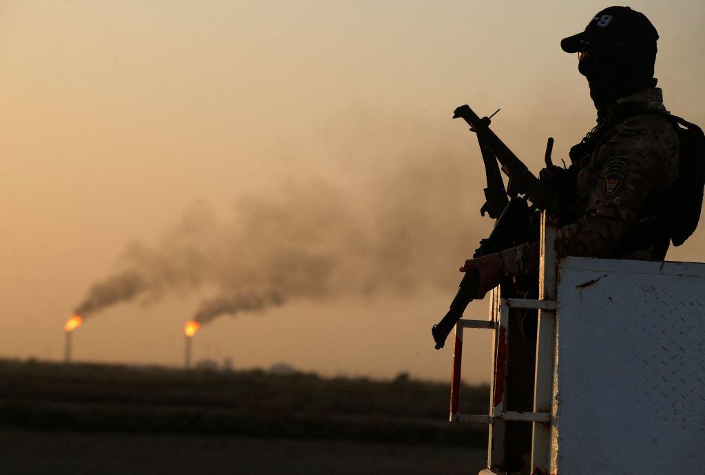 An Iraqi policemen stands guard at the Halfaya oil field belonging to the PetroChina company in the al-Kahla district in the city of Amara south of Baghdad on July 26, 2022. (Photo by AHMAD AL-RUBAYE / AFP) (Photo by AHMAD AL-RUBAYE/AFP via Getty Images)