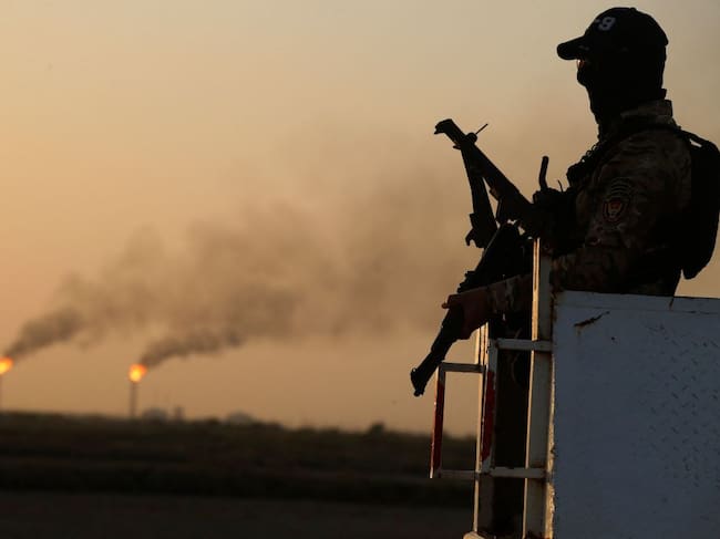 An Iraqi policemen stands guard at the Halfaya oil field belonging to the PetroChina company in the al-Kahla district in the city of Amara south of Baghdad on July 26, 2022. (Photo by AHMAD AL-RUBAYE / AFP) (Photo by AHMAD AL-RUBAYE/AFP via Getty Images)