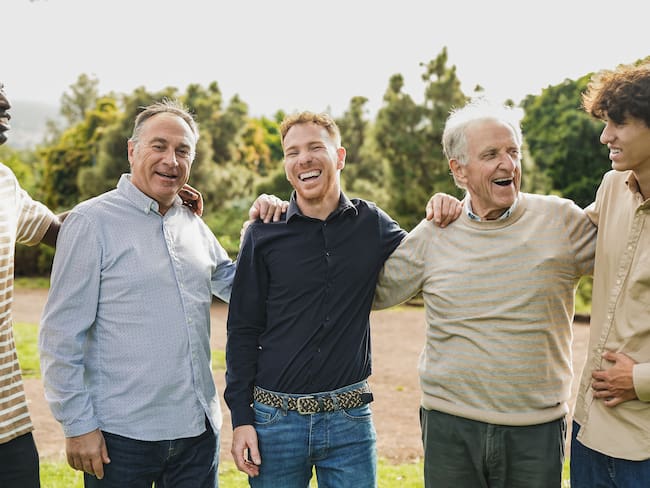 Hombres sonriendo mientras conversan (Foto vía Getty Images)