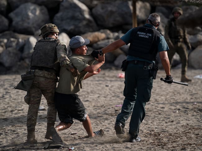 Un miembro de la Guardia Civil detiene a un migrante que ingresó irregularmente a España en Ceuta.
(Foto: Adri Salido/Getty Images)