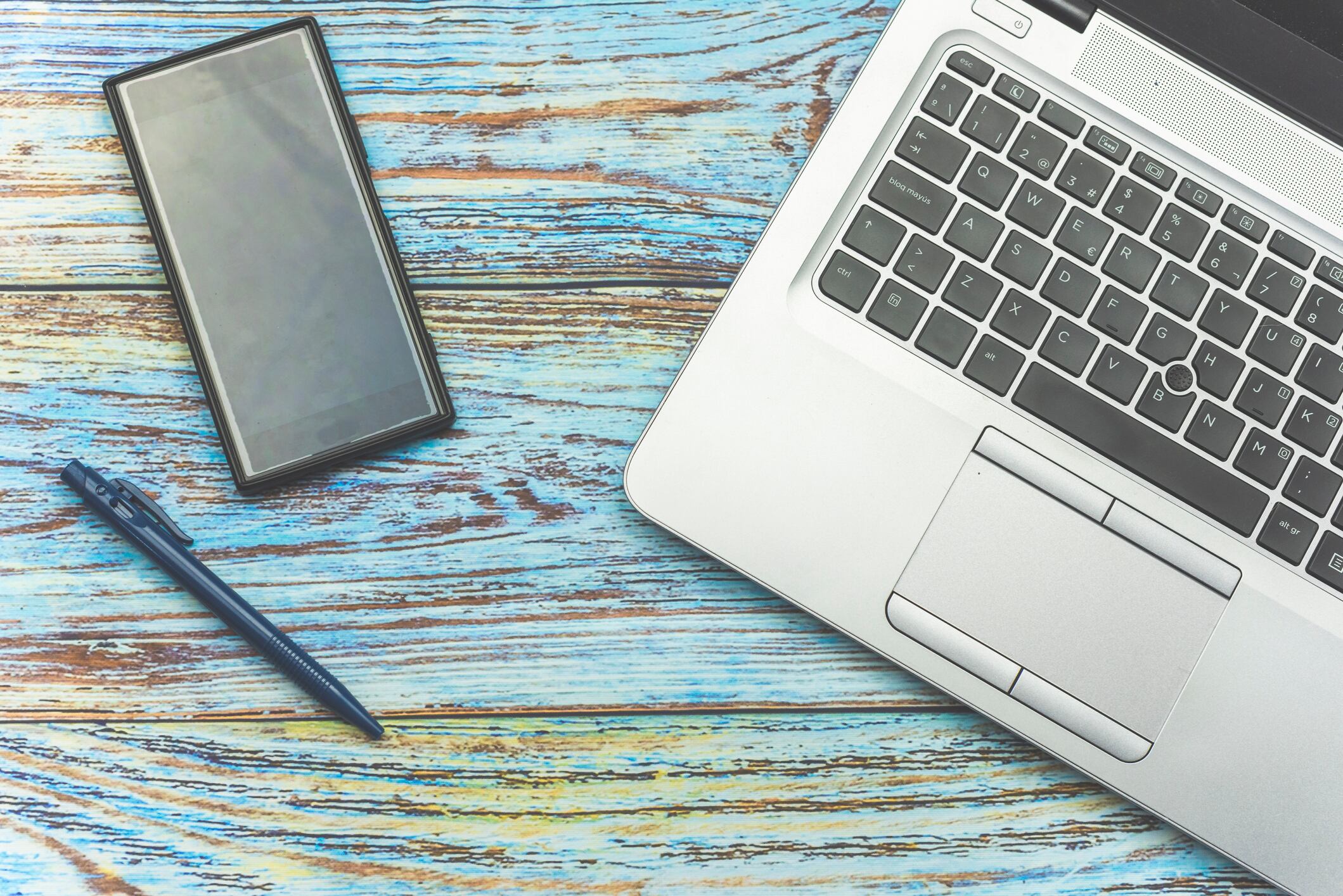 Smartphone and a laptop on a wooden background