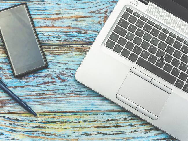 Smartphone and a laptop on a wooden background