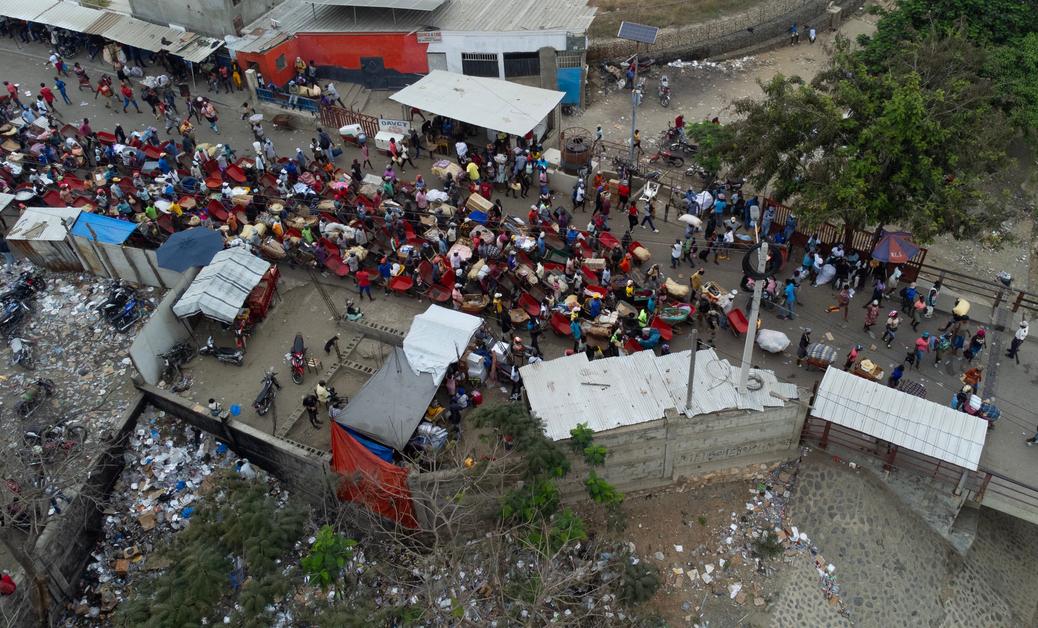 -FOTODELDÍA- AME2331. DAJABÓN (REPÚBLICA DOMINICANA), 25/03/2024.- Haitianos esperan este lunes en el paso de Oaunaminthe (Haití), para cruzar la frontera y abastecerse de productos, principalmente alimentos, en el Mercado Binacional en Dajabón (República Dominicana). El trasiego es continuo en la frontera entre Haití y República Dominicana, en especial en días de mercado como este lunes, cuando miles de haitianos aprovechan para conseguir los productos que escasean en su país y evitar el caos de Puerto Príncipe, asoladas por la violencia de las bandas armadas. Casi la mitad de la población de Haití (4,97 millones de personas de un total de 11 millones), afronta una inseguridad alimentaria aguda debido a la escalada de la violencia y la crisis económica, alertó este lunes la Organización de las Naciones Unidas para la Alimentación (FAO), que pidió tomar medidas urgentes. EFE/Orlando Barría