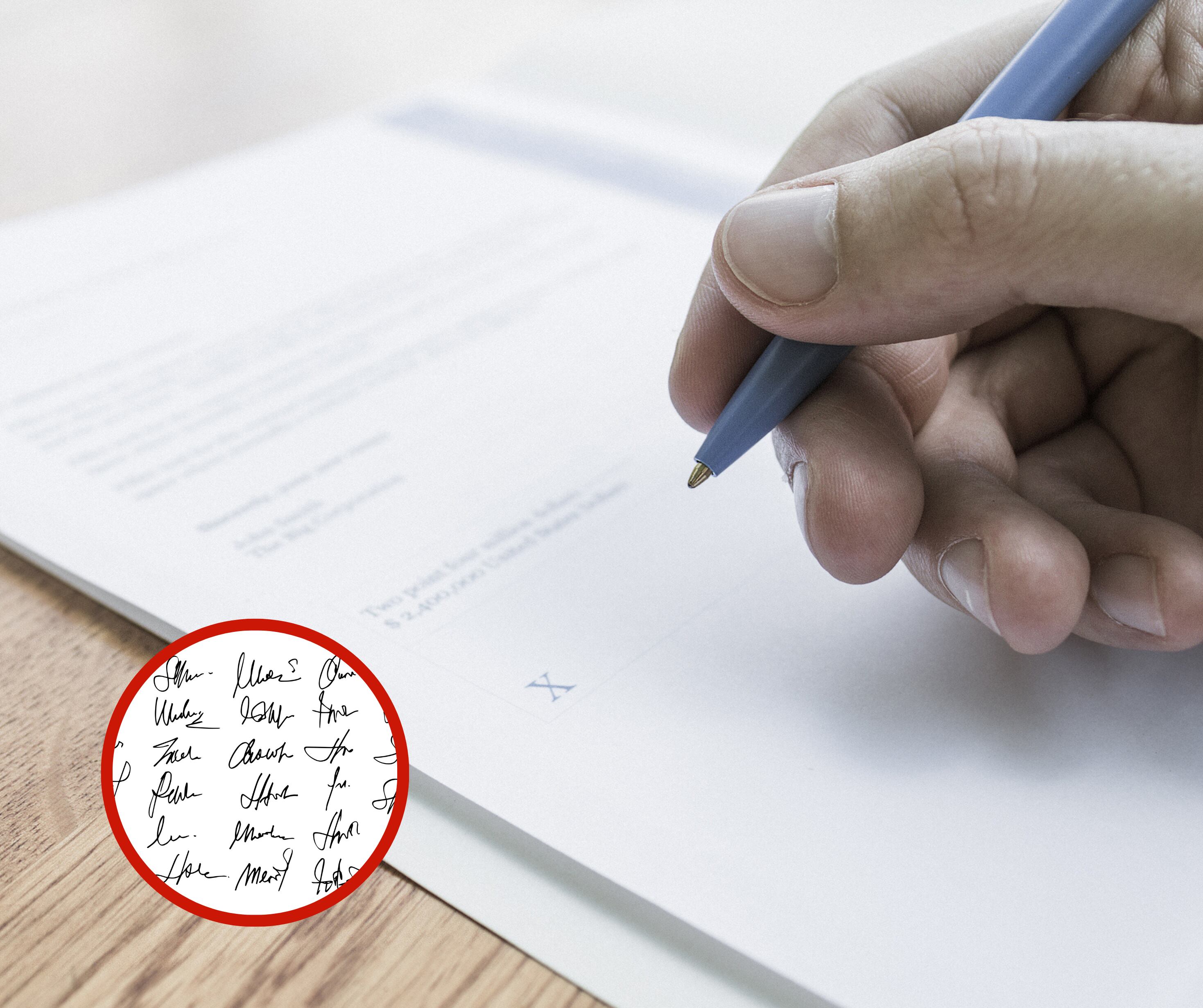 Persona sosteniendo un esfero junto a variedad de firmas (Fotos vía Getty Images)