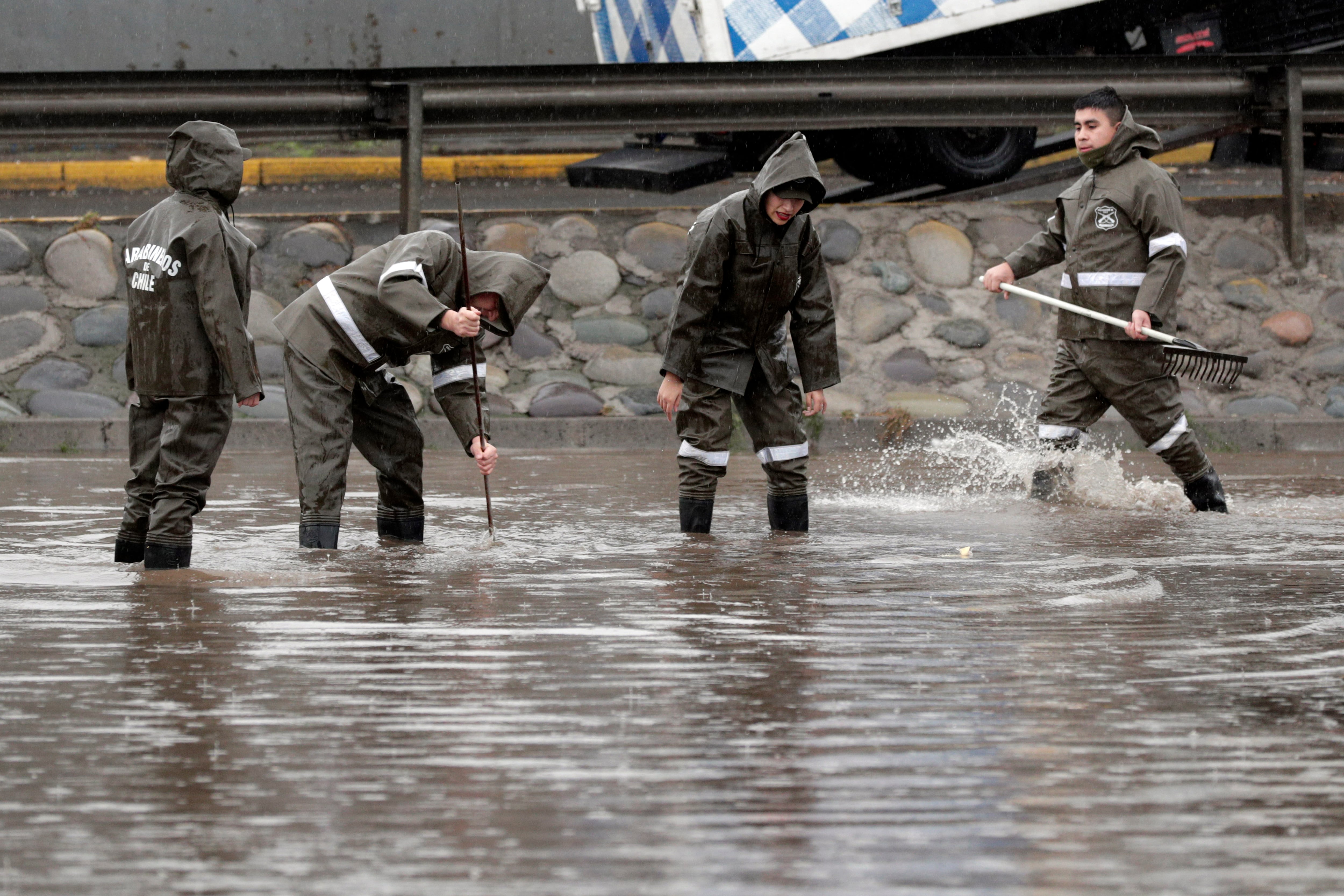 Personal de Carabineros trabaja en calles inundadas por la lluvia, en Santiago (Chile).
EFE/Elvis González
