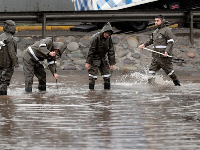 Personal de Carabineros trabaja en calles inundadas por la lluvia, en Santiago (Chile).
EFE/Elvis González