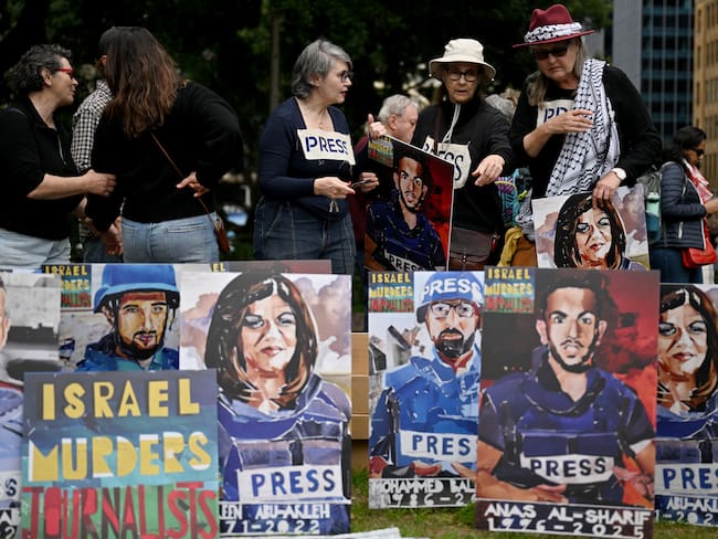 Demonstrators arrange artwork depicting journalists who were killed while performing their duties in Gaza, as they take part in a pro-Palestinian rally against Israel's actions and ongoing food shortages in the Gaza Strip, which the UN officially declared a famine on August 22, during a protest in Sydney's central business district on August 24, 2025. (Photo by Saeed KHAN / AFP)