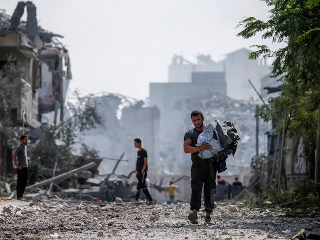 Gaza (---), 10/10/2023.- Palestinians stand in the destroyed Al-Ramal neighborhood following an Israeli air strike in Gaza City, 10 October 2023. More than 700 people have been killed and around 4,000 have been injured according to the Palestinian Ministry of Health, after Israel started bombing the Palestinian enclave in response to an attack carried out by the Islamist movement Hamas on 07 October. More than 3,000 people, including 1,500 militants from Hamas, have been killed and thousands injured in Gaza and Israel since 07 October, according to Israeli military sources and Palestinian officials. EFE/EPA/MOHAMMED SABER