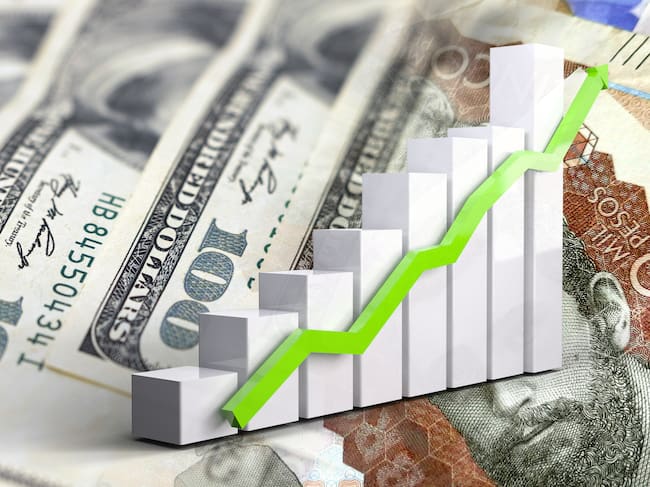 Economy chart: rising arrow, and cash bills of dollars and Colombian pesos (Credito: Javier Ghersi // Getti imagenes)
