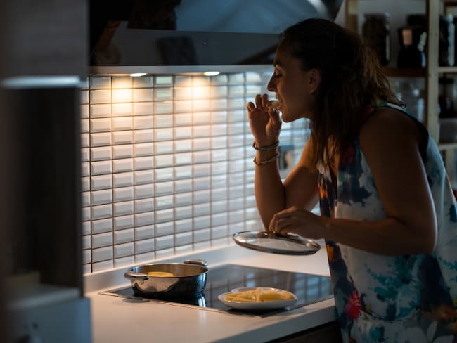 Persona comiendo de noche, imagen de referencia: Getty Images