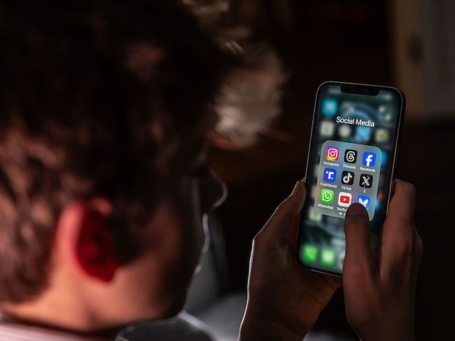 Imagen de referencia de un niño menor de 15 años con un celular y redes sociales. (Matt Cardy / Getty Images)
