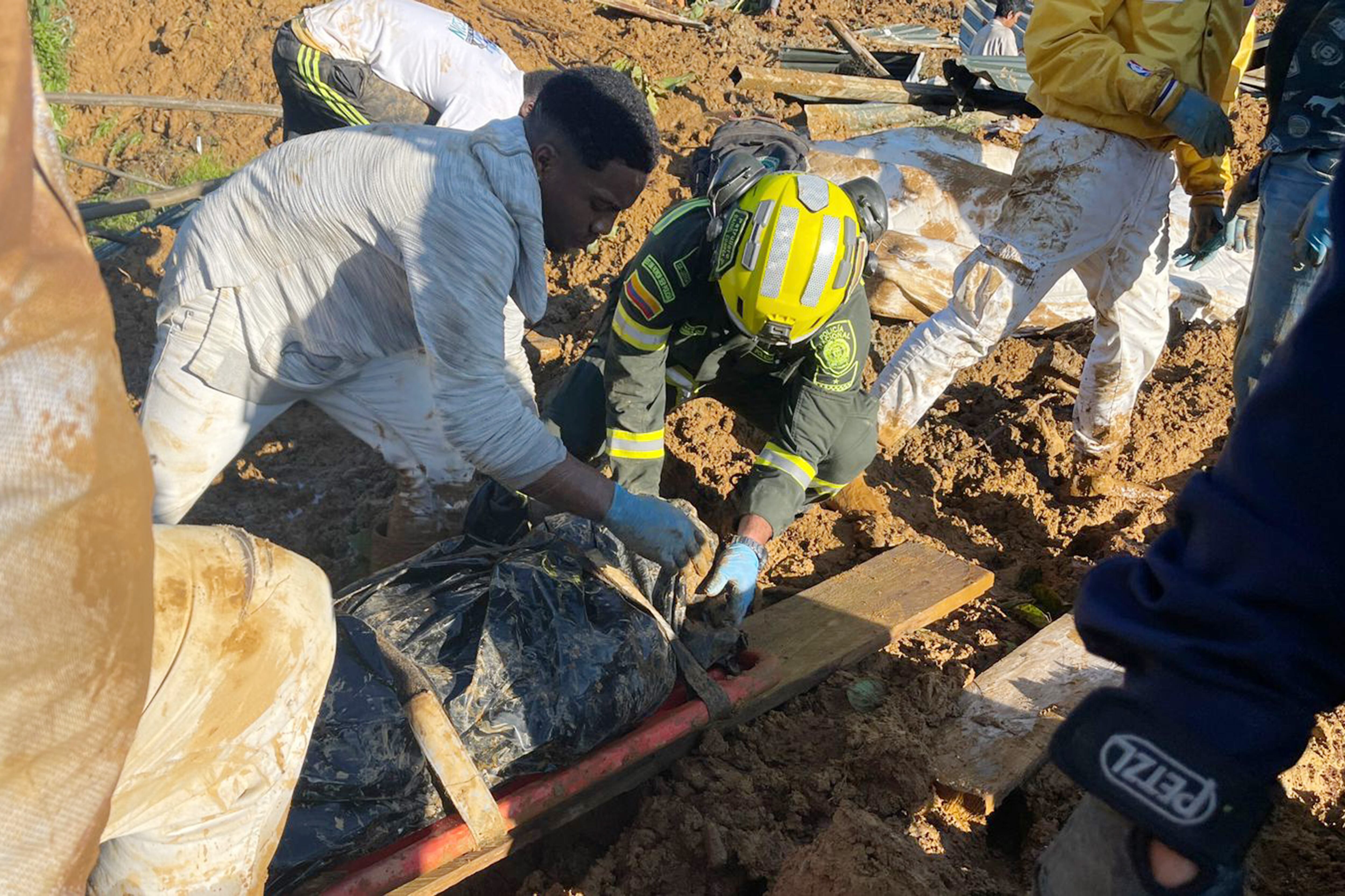 CAR400. CARMEN DE ATRATO (COLOMBIA), 13/01/2024.- Fotografía cedida por la Policía Nacional de Colombia que muestra a rescatistas y policías mientras trabajan en la recuperación de cuerpos hoy, en el lugar donde ocurrió un derrumbe en inmediaciones del municipio Carmen de Atrato, departamento del Chocó (Colombia). Los muertos por dos derrumbes de tierra ocurridos en una carretera cerca de la localidad de El Carmen de Atrato, en el departamento colombiano del Chocó (oeste), ascendieron a 23, mientras que las autoridades de rescate lograron sacar a 25 heridos, informaron este sábado autoridades locales. EFE/ Policía Nacional de Colombia /SOLO USO EDITORIAL SOLO DISPONIBLE PARA ILUSTRAR LA NOTICIA QUE ACOMPAÑA (CRÉDITO OBLIGATORIO)