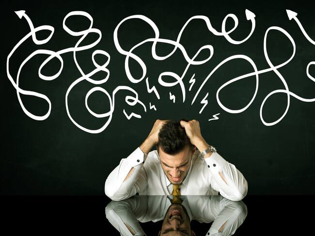 Depressed businessman sitting under white drawn direction lines