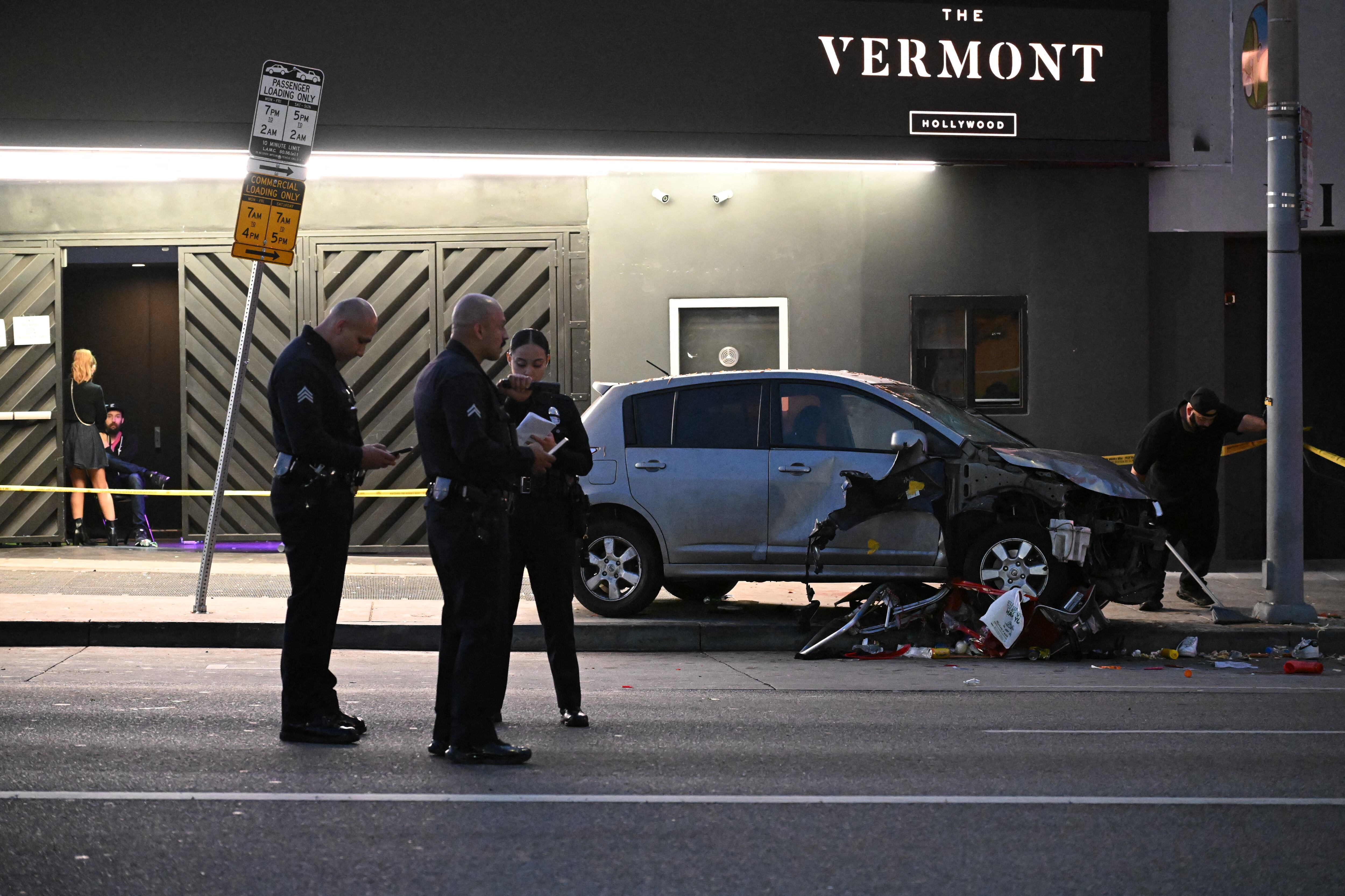 Officers stand at the scene of a crashed vehicle which drove into a crowd in Hollywood in the early hours of July 19, 2025, injuring 28 people, according to the Los Angeles Fire Department. More than 100 firefighters responded to the scene in East Hollywood assisting three patients in critical condition, six in serious condition and 19 listed as fair, the Fire Department said. (Photo by Robyn Beck / AFP)