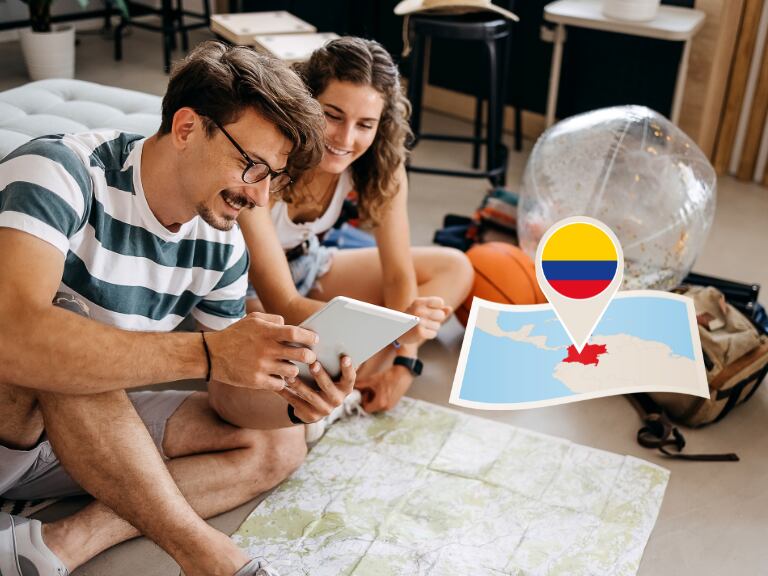 Jóvenes eligiendo su próximo destino con un mapa en el piso / mapa de Colombia (Getty Images)