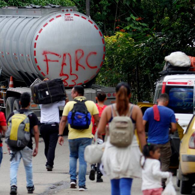 AME1809. BOGOTÁ (COLOMBIA), 21/01/2025.- Fotografía de archivo del 16 de agosto de 2023 de personas caminando junto a un camión con la frase "FARC 33" en la Vereda Santa Rosa, en Catatumbo (Colombia). Los enfrentamientos entre la guerrilla Ejército de Liberación Nacional (ELN) y una disidencia de las FARC en la región colombiana del Catatumbo, con al menos 80 muertos y cerca de 20.000 desplazados, han hecho que el país vuelva a mirar a esa región del noreste que lleva décadas sometida a la violencia de grupos guerrilleros, paramilitares y narcotraficantes. EFE/ Mario Caicedo /ARCHIVO