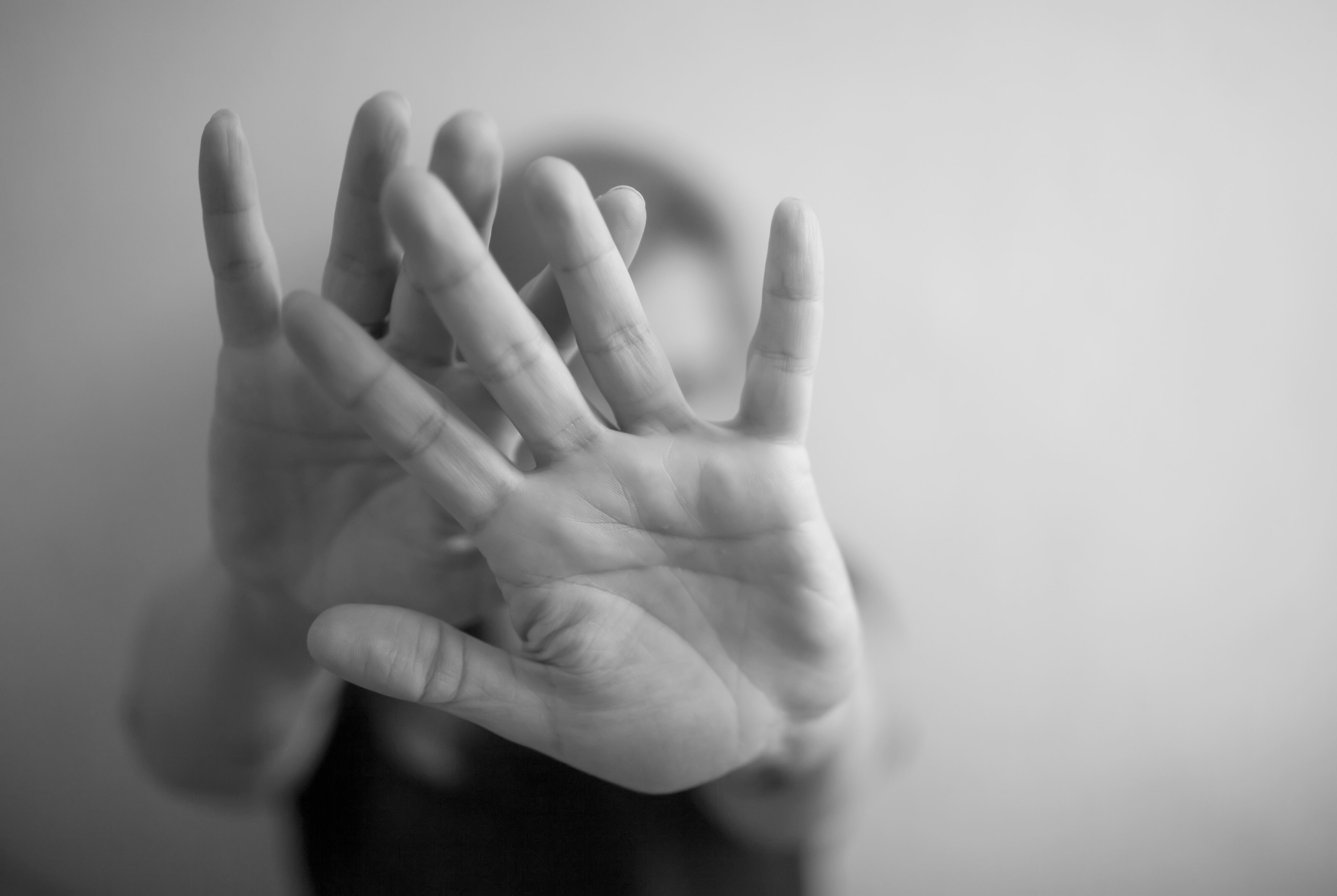 A young woman protects herself by hand