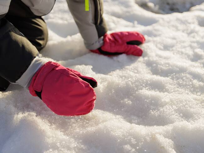 Persona tocando la nieve (Foto vía Getty Images)