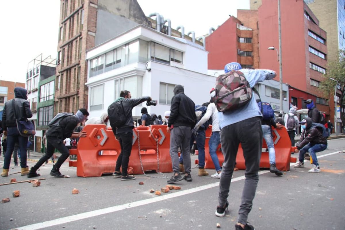 Encapuchados preparan la calle para enfrentamiento con miembros de la policía.