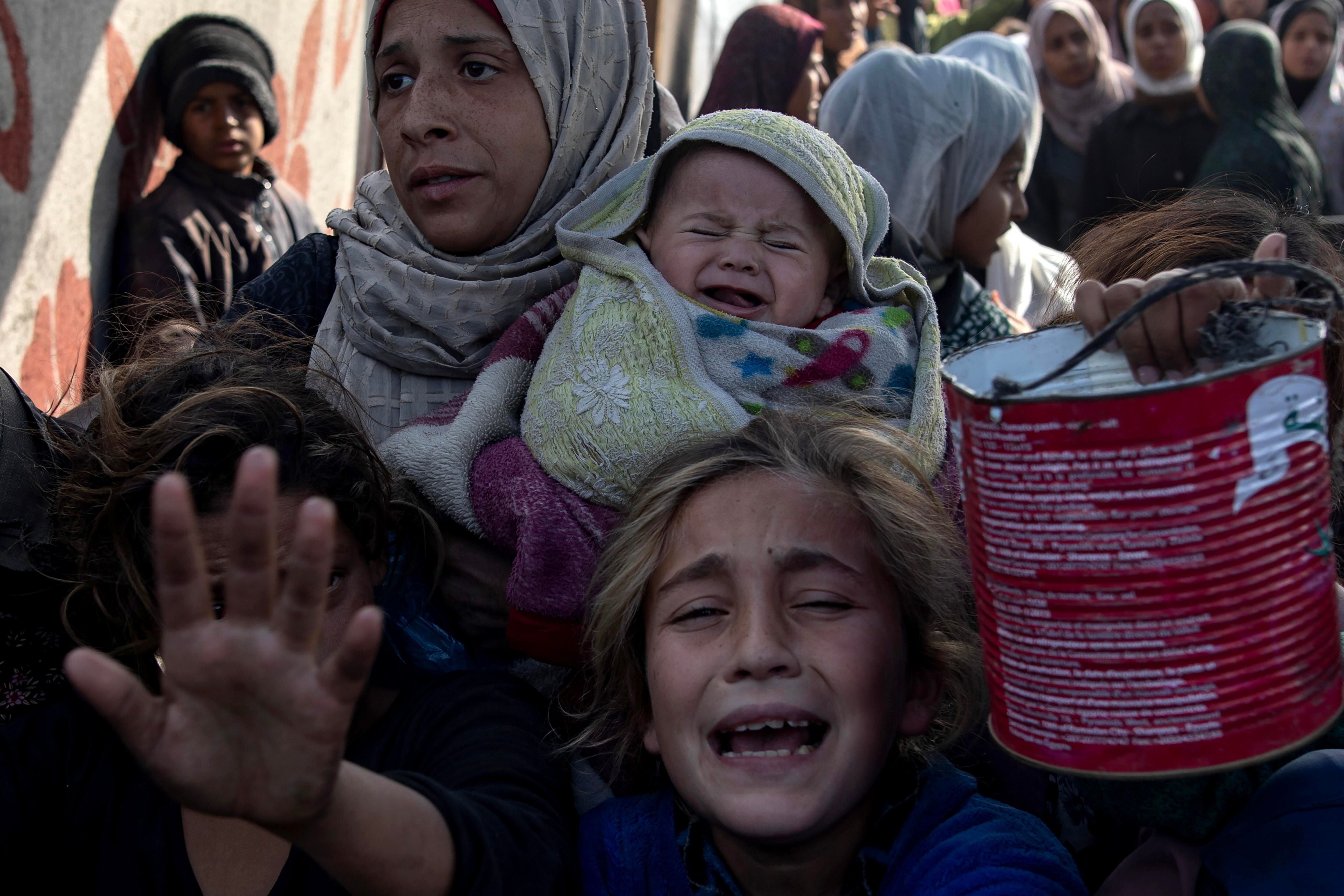 -FOTODELDIA- Khan Yunis (-), 10/01/2025.- Palestinos, incluidos niños, sostienen ollas, latas y sartenes para recibir alimentos cocinados por una cocina de caridad, en Khan Yunis, sur de la Franja de Gaza, este 10 de enero de 2025. EFE/HAITHAM IMAD