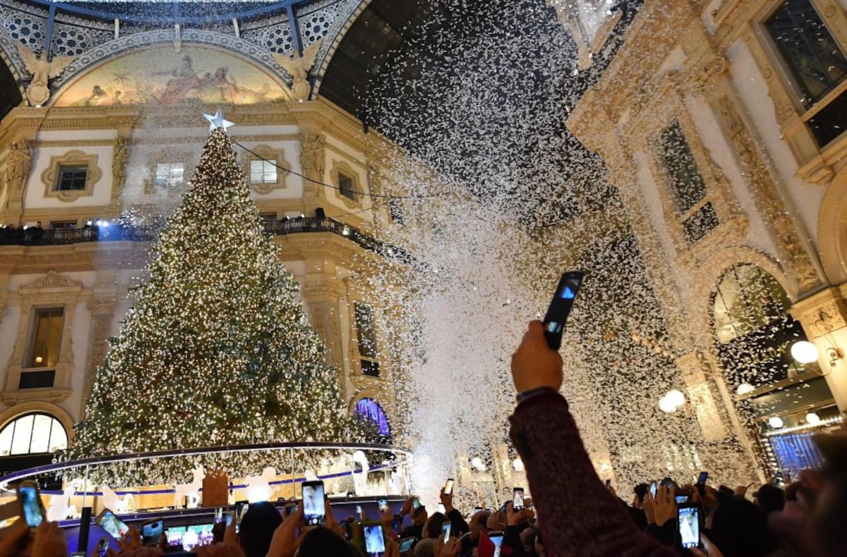 Una multitud toma fotografías durante la ceremonia en la que se han encendido las decoraciones navideñas, incluido el árbol de Navidad de Swarovski, en Milán (Italia)