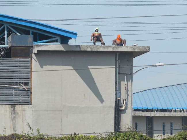 Dos presos toman el sol en el techo del Centro de Privación de Libertad Guayas #1 en Guayaquil. 