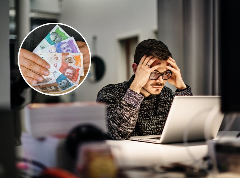 Hombre cansado trabajando hasta tarde en su oficina / Dinero de Colombia (Getty Images)
