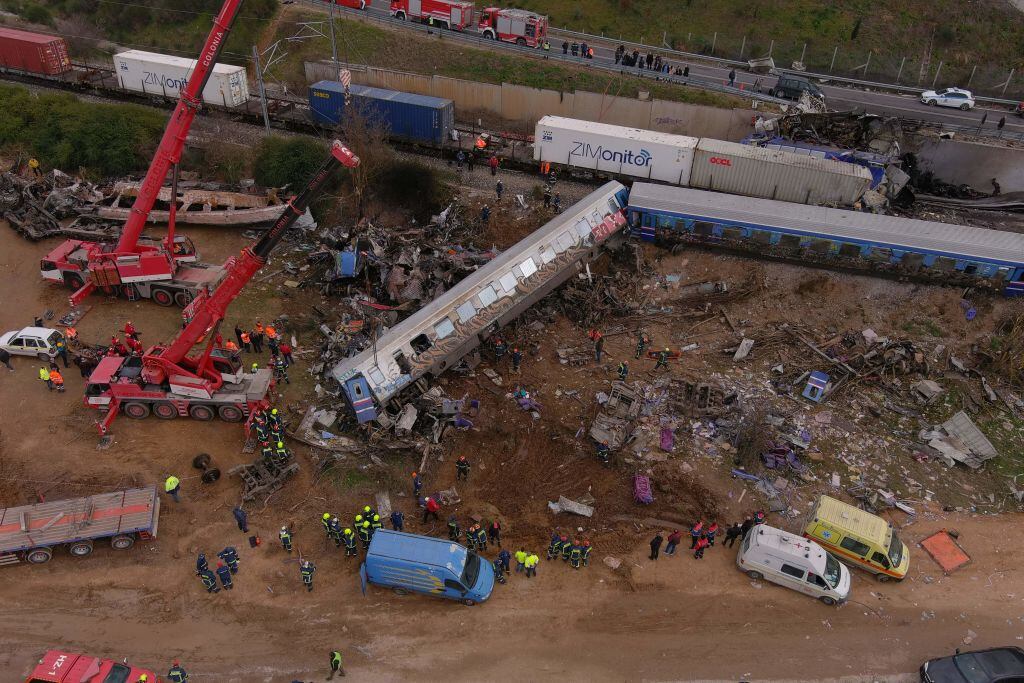 This aerial drone photograph taken on March 1, 2023, shows emergency crews examining the wreckage after a train accident in the Tempi Valley near Larissa, Greece. - At least 32 people were killed and another 85 injured after a collision between two trains caused a derailment near the Greek city of Larissa late at night on February 28, 2023, authorities said. A fire services spokesman confirmed that three carriages skipped the tracks just before midnight after the trains -- one for freight and the other carrying 350 passengers - collided about halfway along the route between Athens and Thessaloniki. (Photo by STRINGER / AFP) (Photo by STRINGER/AFP via Getty Images)