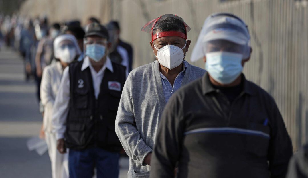 Ciudadanos hacen fila para votar hoy en un centro electoral en el distrito de Villa El Salvador, en Lima