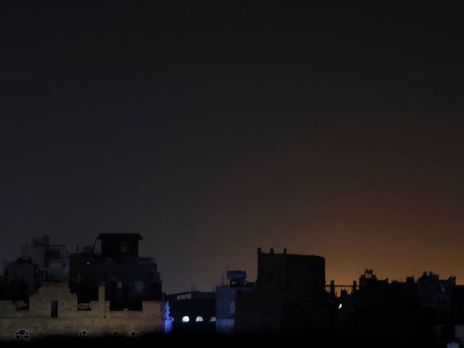 Sana'a (Yemen), 03/02/2024.- A general view of light shining behind buildings at a neighborhood following strikes in Sana'a, Yemen, 03 February 2024. The US-led coalition has conducted new strikes against Yemen's Houthi positions in the capital Sana'a and others cities under Houthis control in response to increased Houthi attacks on shipping in the Red Sea and the Gulf of Aden, Houthis-run al-Masirah TV reported. In January 2024, the US Department of State designated Yemen's Houthis as a 'Specially Designated Global Terrorist group' due to their increased attacks on shipping lanes. In December 2023, the US Department of Defense announced a multinational operation to safeguard trade and protect ships in the Red Sea in response to the escalation of Houthi attacks. (Terrorista) EFE/EPA/YAHYA ARHAB