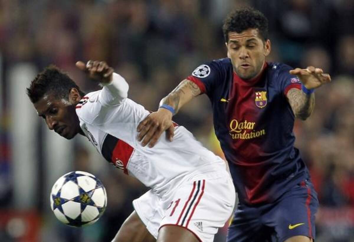 El defensa brasileño del Barcelona Daniel Alves y el centrocampista guineano del AC Milan Kévin Constant luchan por el balón.