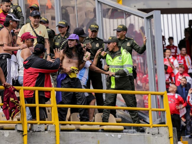 La Policía intercepta a uno de los hinchas del Tolima que estaba ocasionando desmanes desde la tribuna norte del estadio El Campín / Colprensa.