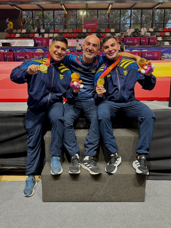 Edwin Gómez y Andrés Restrepo celebran con su entrenador la conquista de la medalla de oro alcanzada en los Juegos Suramericanos 2026 / Foto: Juegos Suramericanos.