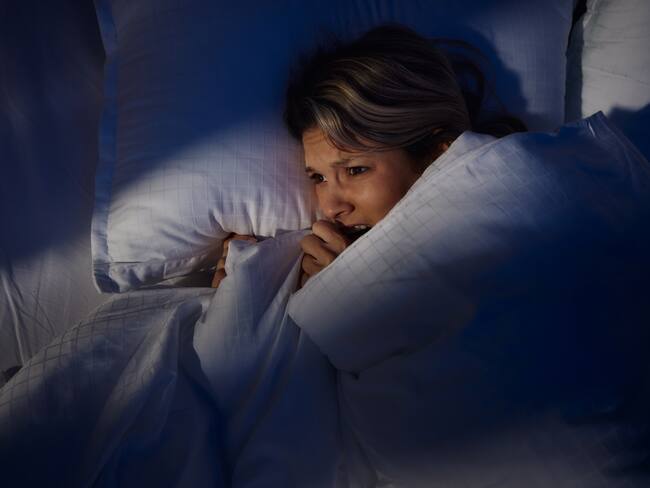 Mujer atemorizada por una pesadilla durante el sueño (Foto vía Getty Images)