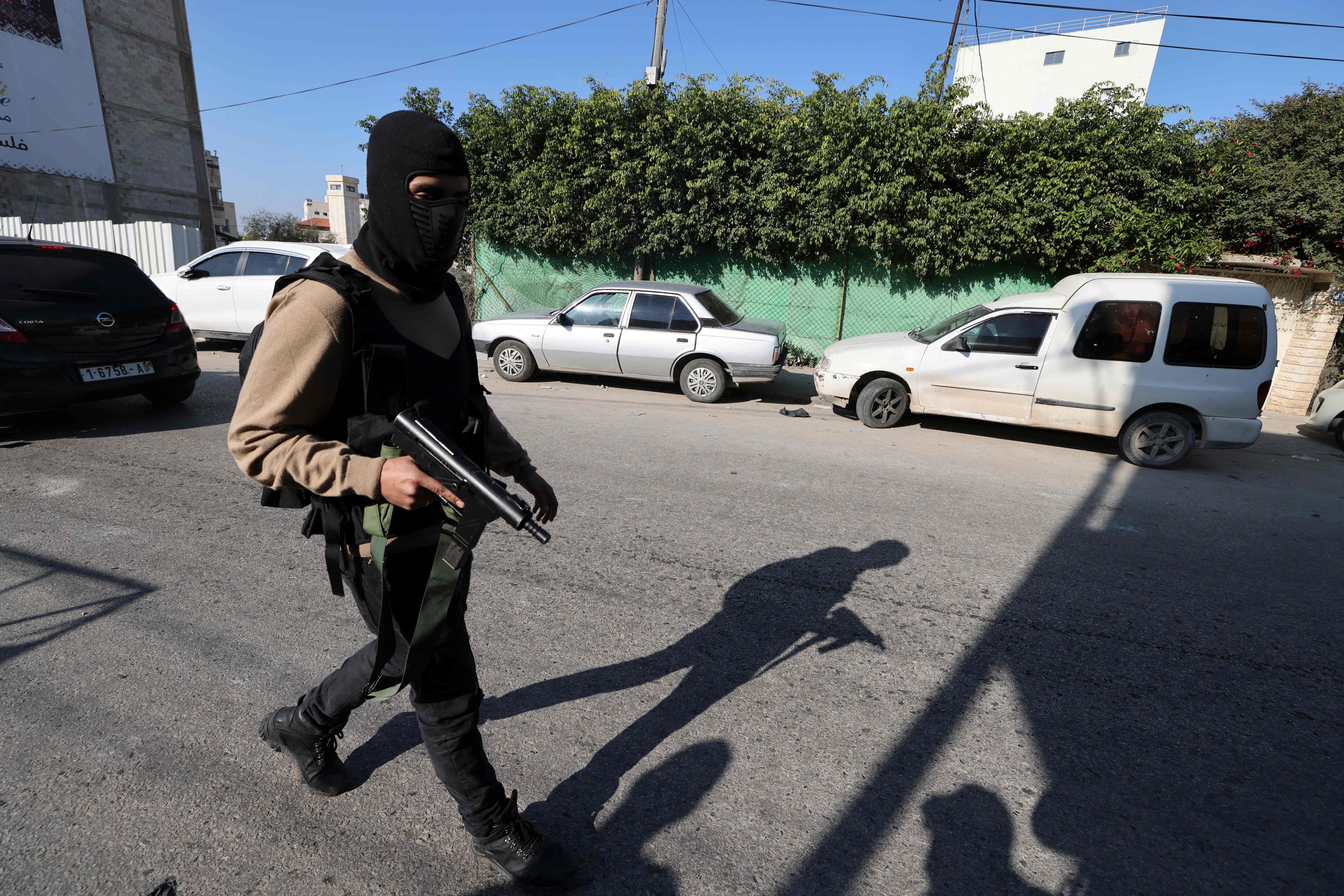 A Palestinian gunman walks following an Israeli raid on the West Bank's Jenin refugee camp, on January 26, 2023. - An Israeli raid on Jenin refugee camp today killed 9 Palestinians including an elderly woman, Palestinian officials said, also accusing the army of using tear gas inside a hospital. (Photo by Jaafar ASHTIYEH / AFP) (Photo by JAAFAR ASHTIYEH/AFP via Getty Images)