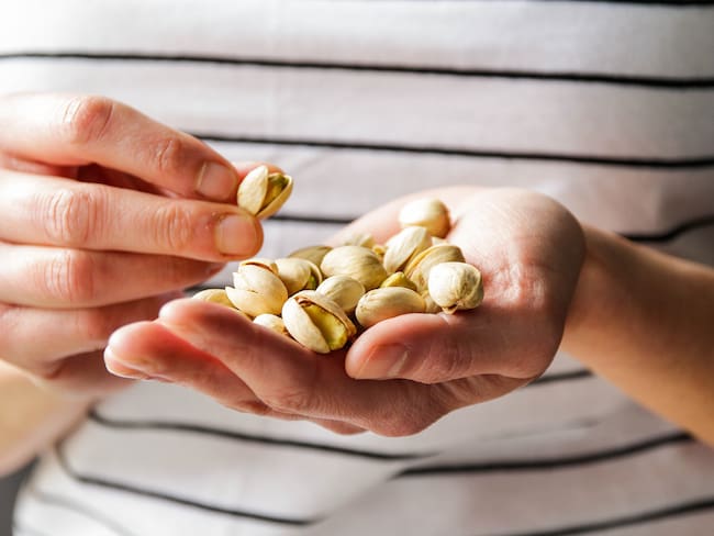Persona con pistachos en su mano (Foto vía Getty Images)