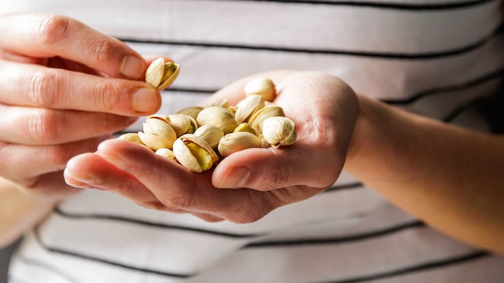 Persona con pistachos en su mano (Foto vía Getty Images)