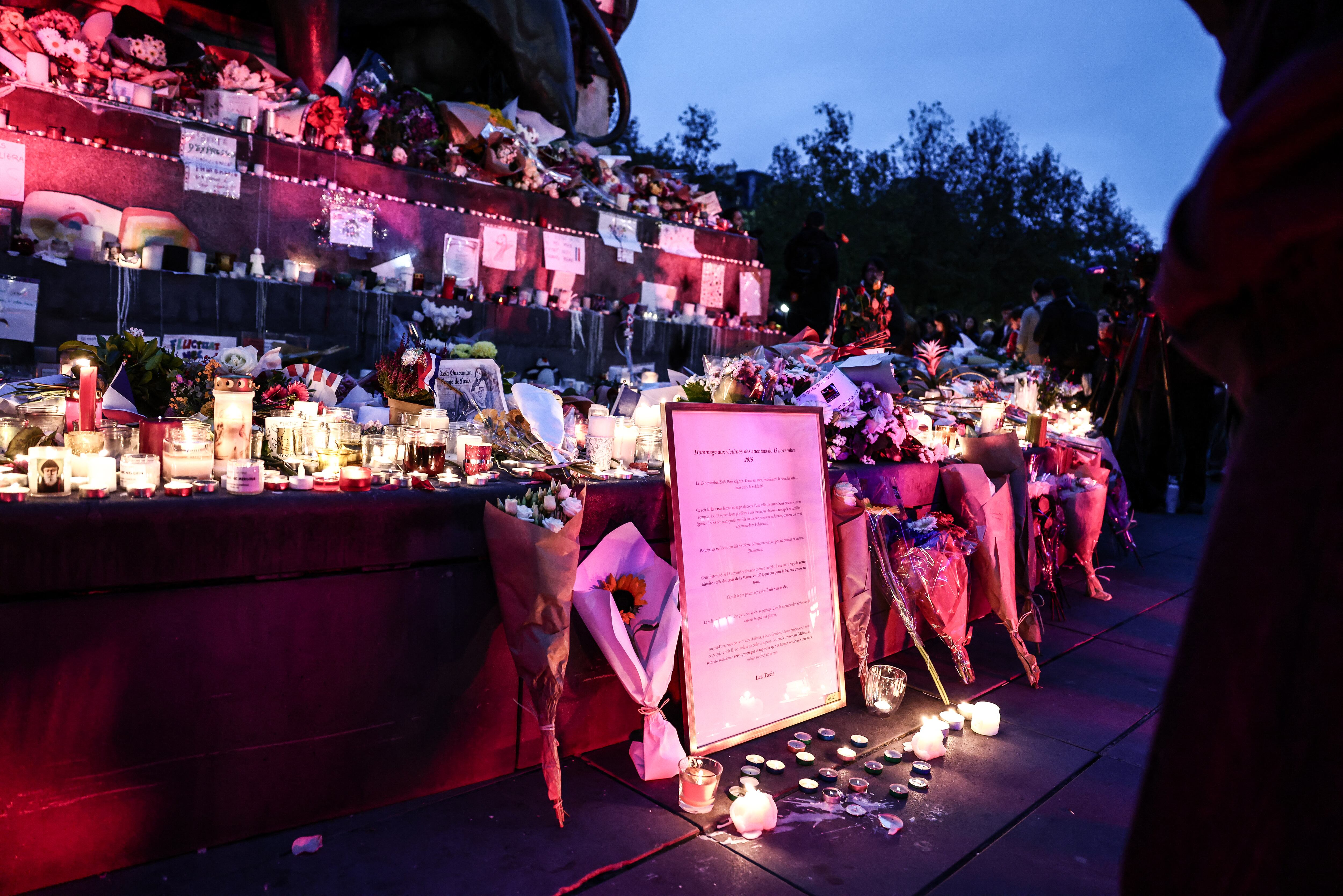 This photograph shows flowers and candles at a makeshift memorial at the Place de la Republique in Paris on November 13, 2025, during the anniversary marking a decade since the terror attacks of November 13, 2015 in which 130 civilians were killed. (Photo by Thibaud MORITZ / AFP)