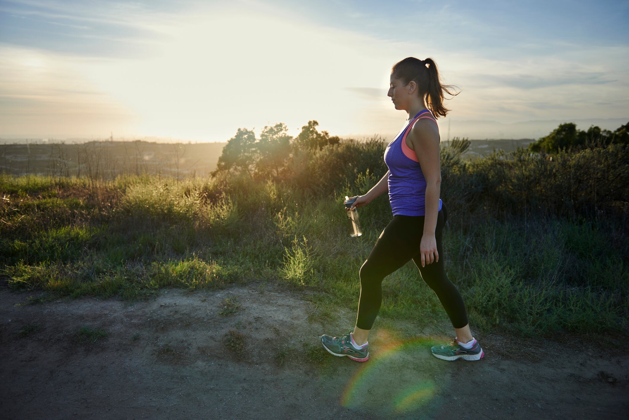 Mujer haciendo ejercicio caminando sobre una montaña (Getty Images)