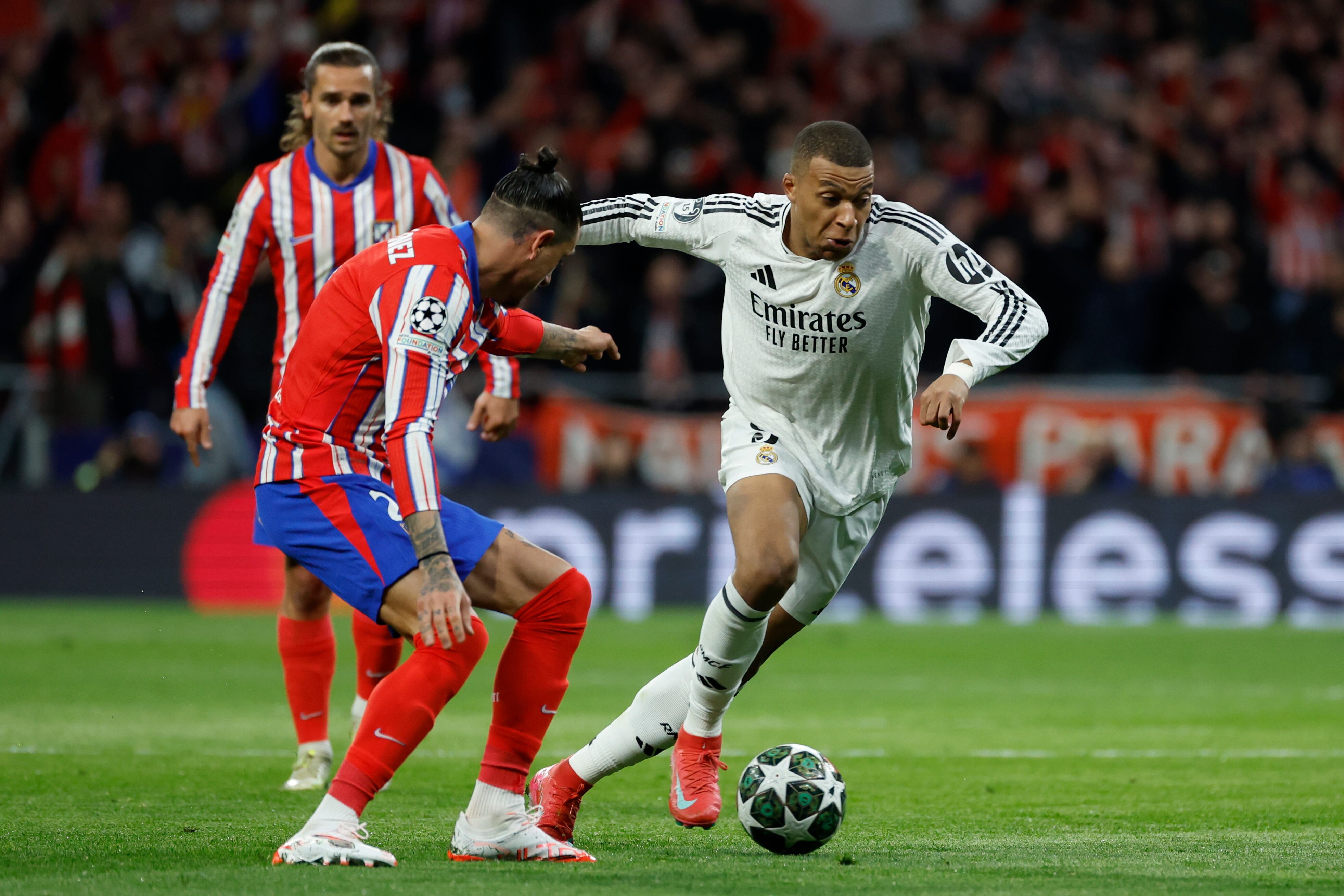 El delantero francés del Real Madrid, Kylian Mbappé (d), se lleva el balón ante el defensa uruguayo del Atlético de Madrid, José María Giménez, durante el partido de vuelta de los octavos de final de la Liga de Campeones que Atlético de Madrid y Real Madrid disputan este miércoles en el estadio Metropolitano. EFE/Juanjo Martín