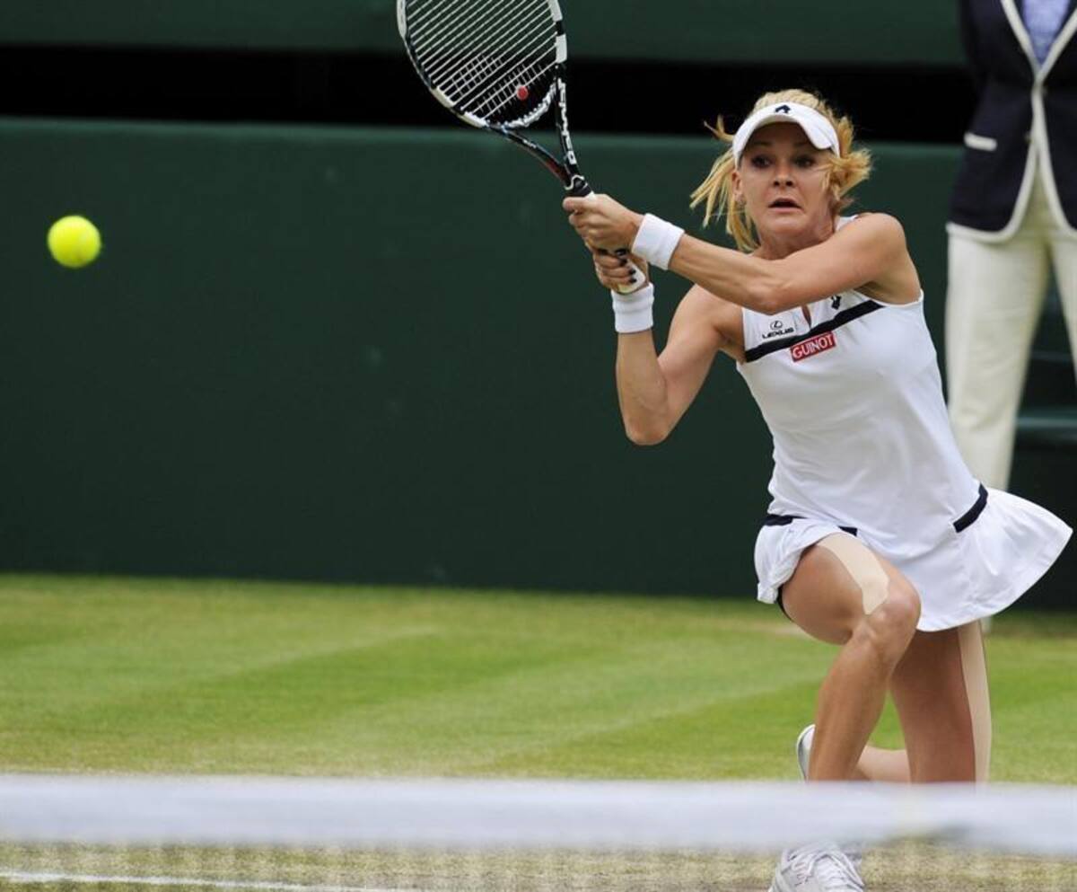La tenista polaca Agnieszka Radwanska devuelve una bola a la china Na Li, durante el partido de cuartos de final del torneo de tenis de Wimbledon.