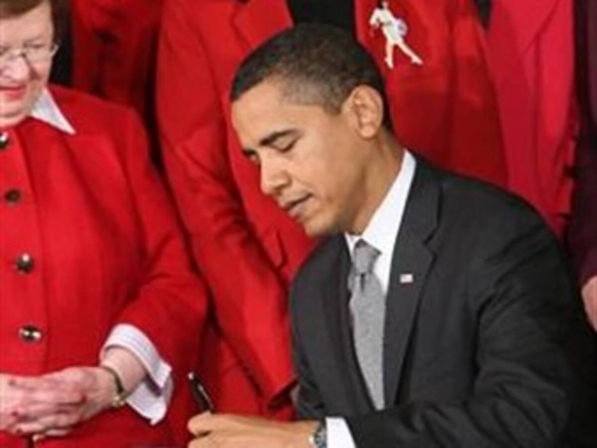 El presidente Barack Obama firma su primera ley como presidente en emotivo acto con activista