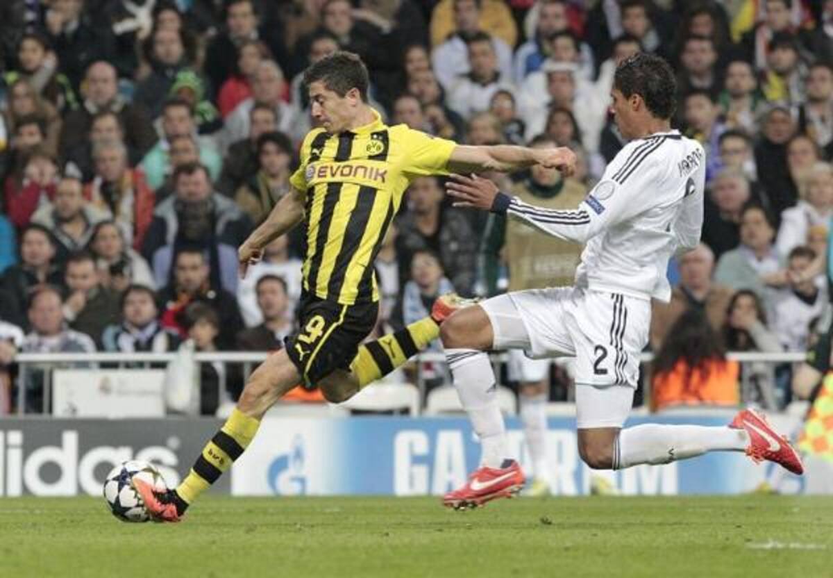 Varane defiende el balón tras la entrada de Lewandowski.