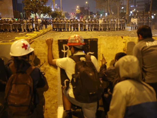 Demonstrators clash with anti-riot police officers during protests against Peru's interim President Jose Jeri in Lima on October 15, 2025. (Photo by Hugo CUROTTO / AFP)