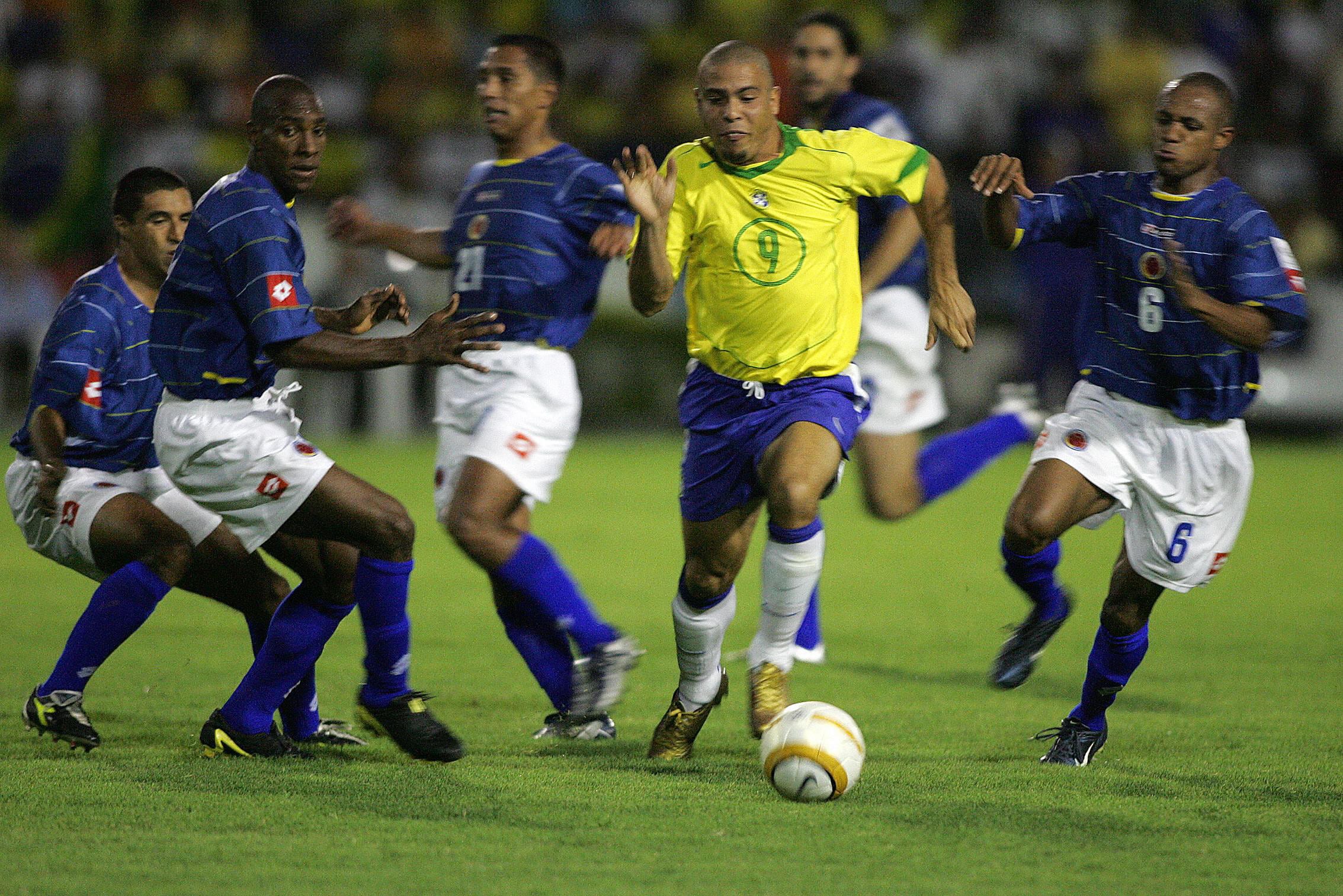 Ronaldo elude jugadores colombianos durante un partido disputado en octubre del 2004.  (Photo credit should read ORLANDO KISSNER/AFP via Getty Images)