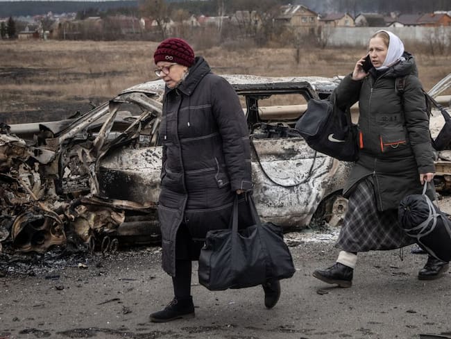 Mujeres salen de Irpin en Ucrania con sus pocas pertenencias